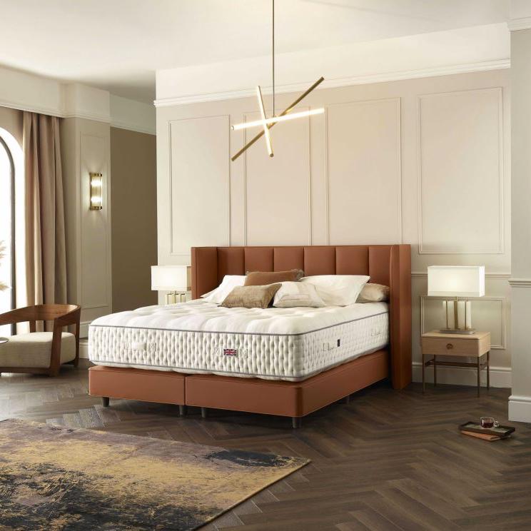 Harrison Spinks Strand Mattress in a styled room with brown headboard and base.